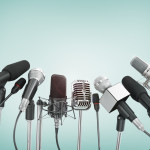 Various microphones aligned at press conference.