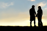 Silhouette of Happy Couple Holding Hands and Talking at Sunset